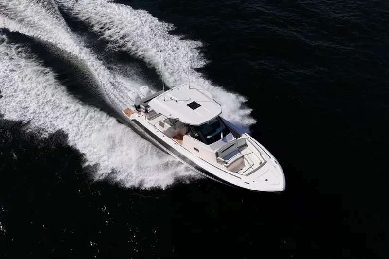 Slide: The Image of 2023 Tiara Yachts 34 LS cruising on open water, creating a dynamic wake. - 5
