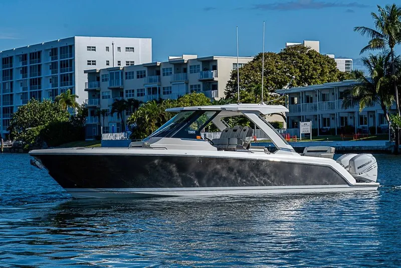 Slide: The Image of 2023 Tiara Yachts 34 LS luxury boat on water near modern buildings. - 9