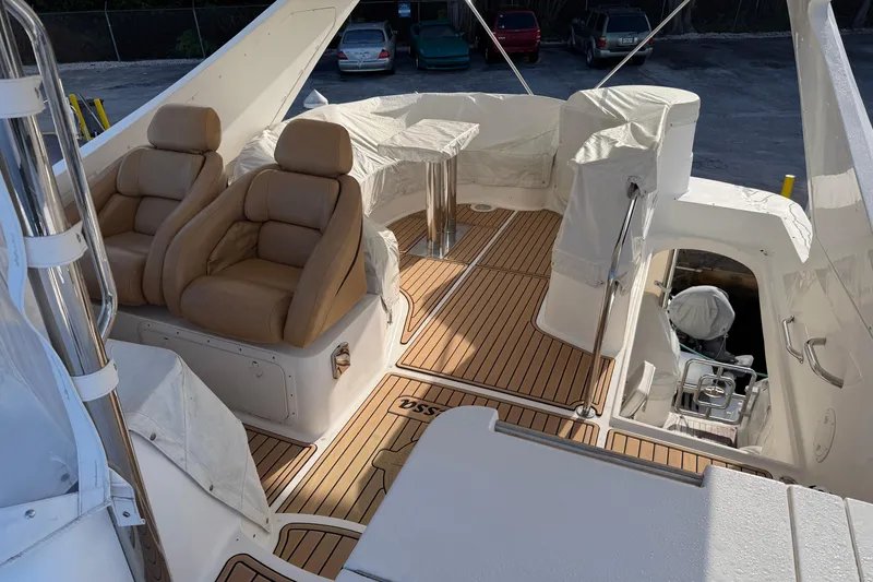 Slide: The Image of 2006 Neptunus 56 Flybridge yacht interior with tan leather seats and wooden flooring. - 11