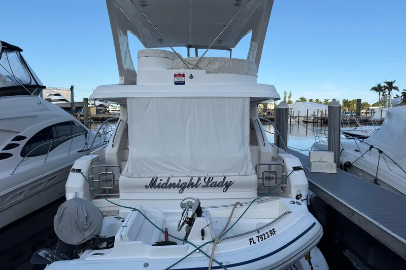 Slide: The Image of 2006 Neptunus 56 Flybridge yacht docked, named "Midnight Lady," with covered flybridge. - 2