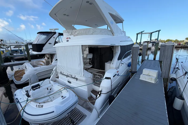 Slide: The Image of 2006 Neptunus 56 Flybridge yacht docked at marina with inflatable boat. - 3