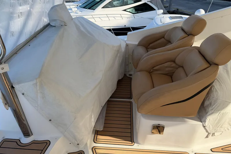 Slide: The Image of 2006 Neptunus 56 Flybridge with covered controls and tan leather seats. - 4
