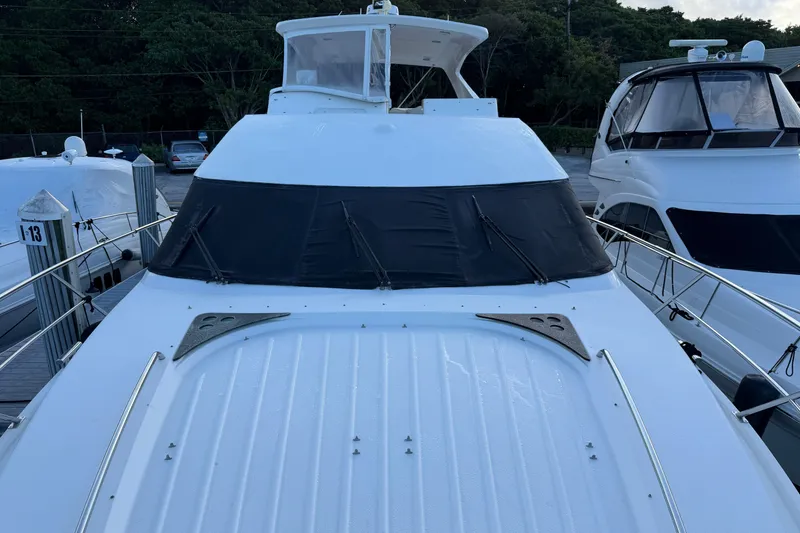 Slide: The Image of 2006 Neptunus 56 Flybridge yacht docked at marina, front view. - 56