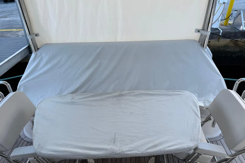 Slide: The Image of 2006 Neptunus 56 Flybridge yacht deck with covered seating and table. - 57