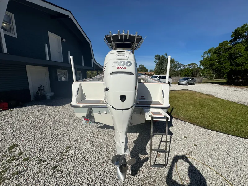 Slide: The Image of 2019 Mako 214C boat with 200 Pro engine, parked on gravel near a building. - 14