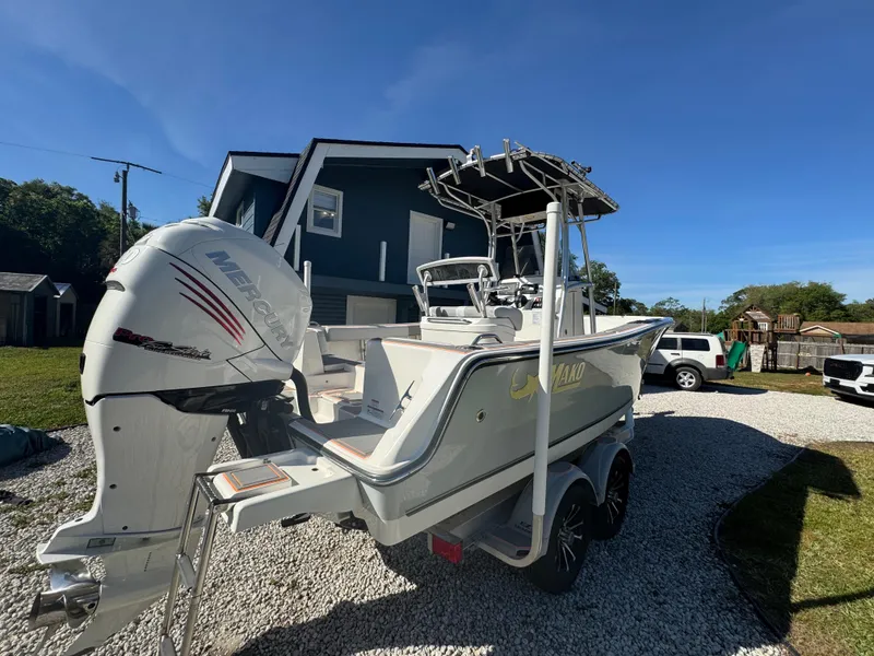 Slide: The Image of 2019 Mako 214C boat with outboard motor on a trailer in a residential driveway. - 18