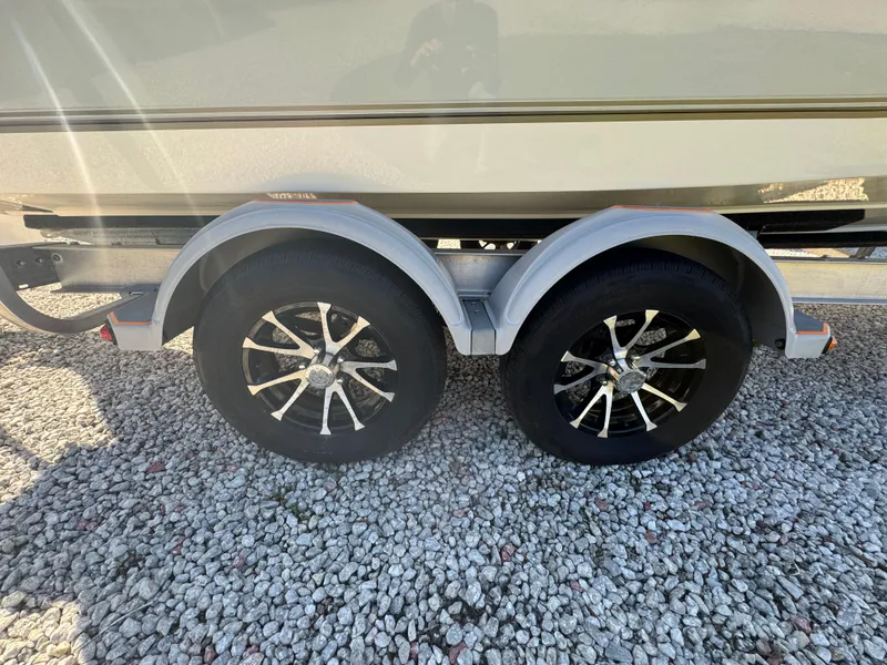 Slide: The Image of 2019 Mako 214C trailer with dual black alloy wheels on gravel surface. - 20