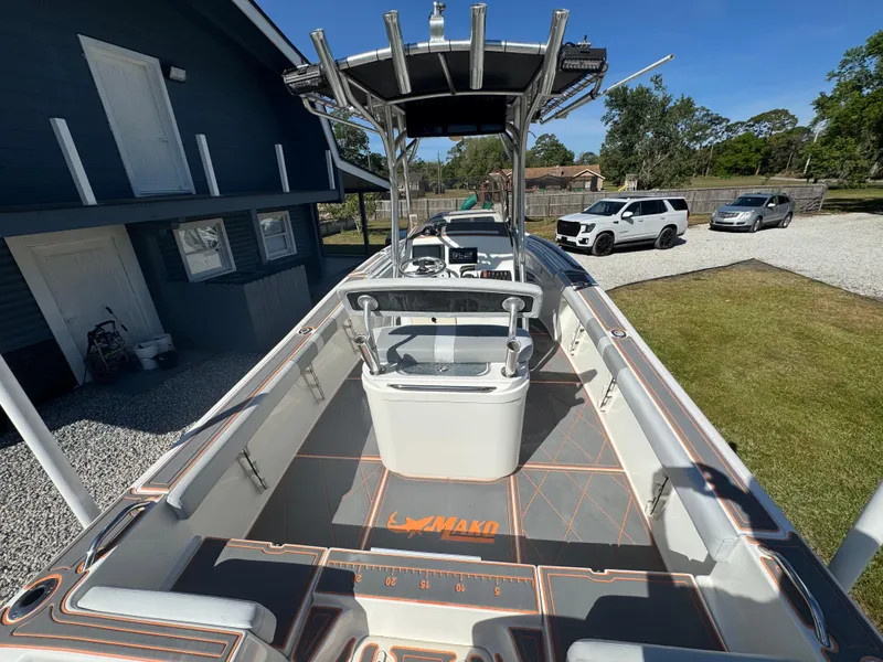 Slide: The Image of 2019 Mako 214C boat with center console, parked near a house and cars. - 29
