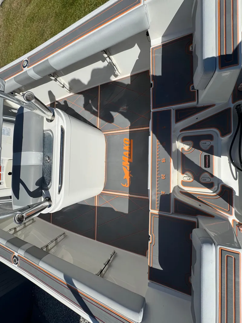 Slide: The Image of 2019 Mako 214C boat interior with seating and console, featuring orange accents. - 30