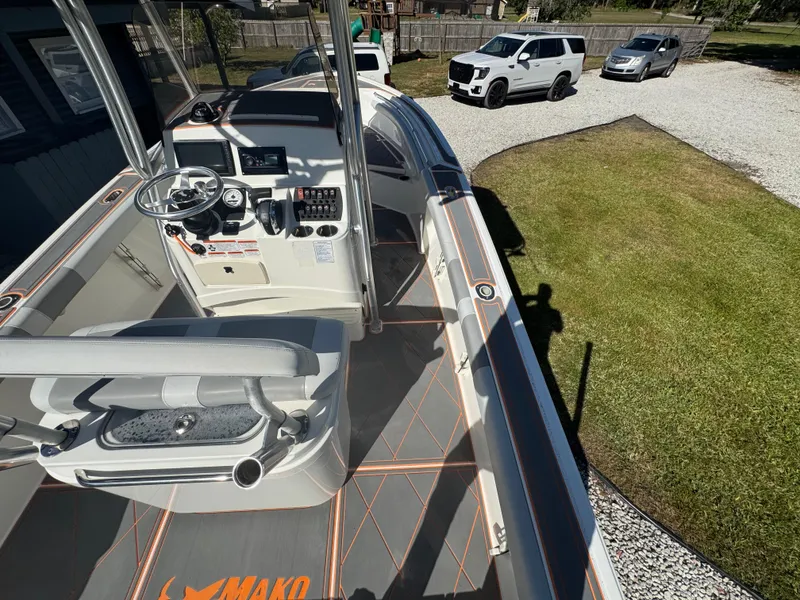 Slide: The Image of 2019 Mako 214C boat interior with steering console, parked on gravel near vehicles. - 33