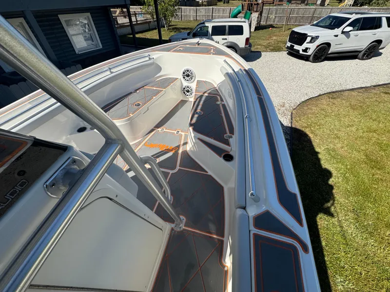 Slide: The Image of 2019 Mako 214C boat with sleek design, parked near vehicles in a driveway. - 37