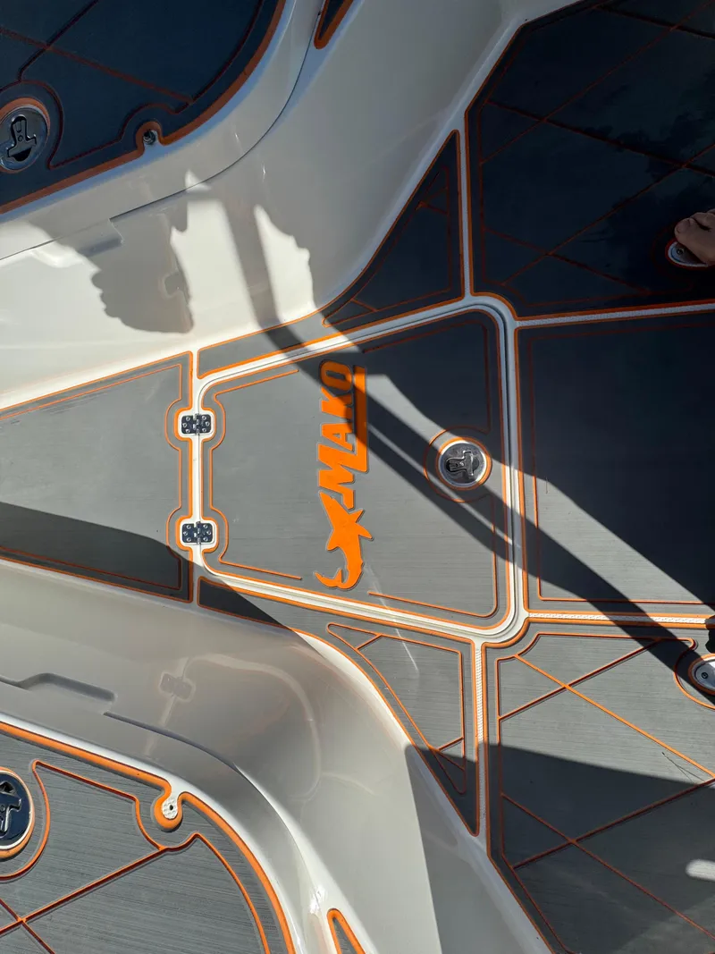 Slide: The Image of Deck of a 2019 Mako 214C boat with orange logo and sleek design. - 40