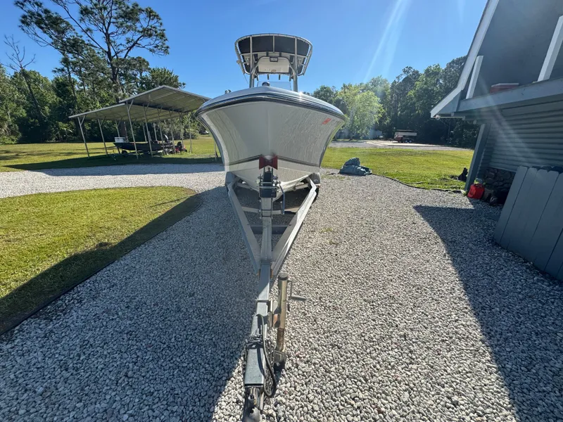 Slide: The Image of 2019 Mako 214C boat on trailer, parked on gravel driveway under clear blue sky. - 7