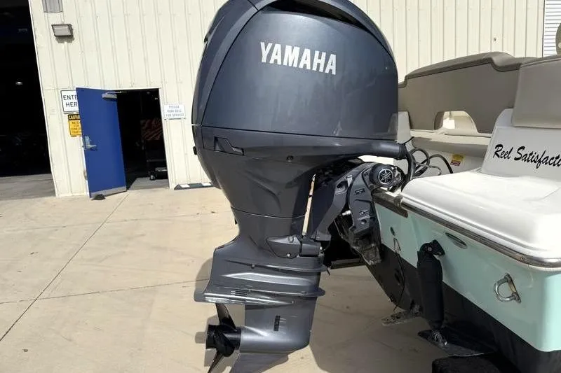 Slide: The Image of 2024 Key West 203 FS boat with Yamaha outboard motor, docked outside a building. - 13
