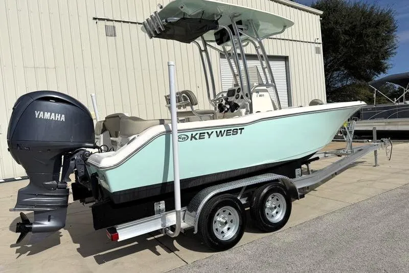 Slide: The Image of 2024 Key West 203 FS boat on trailer with Yamaha engine, parked outdoors. - 2