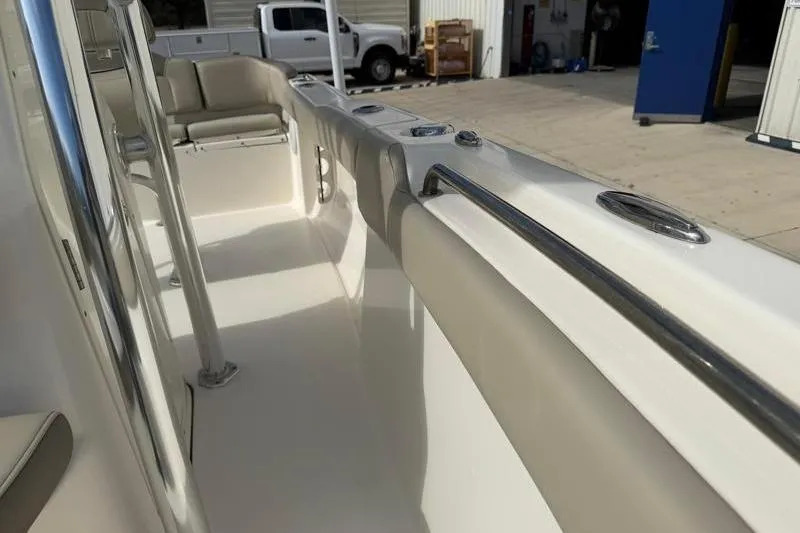 Slide: The Image of 2024 Key West 203 FS boat interior with beige seating and stainless steel railings. - 23