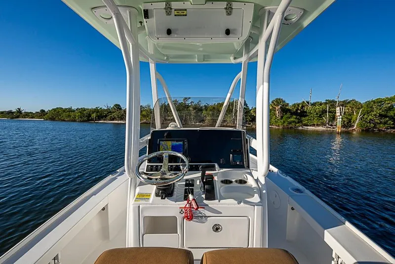 Slide: The Image of 2019 Sea Hunt BX 22 BR boat interior with steering console on calm water. - 19