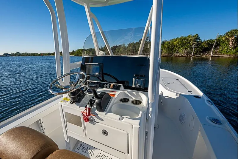 Slide: The Image of 2019 Sea Hunt BX 22 BR boat interior with steering console on a sunny day. - 20
