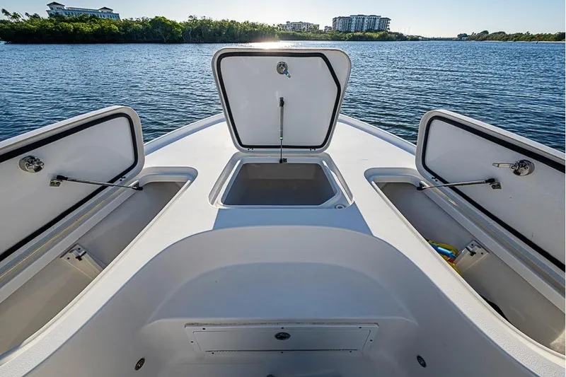 Slide: The Image of 2019 Sea Hunt BX 22 BR boat with open storage compartments on a calm lake. - 33