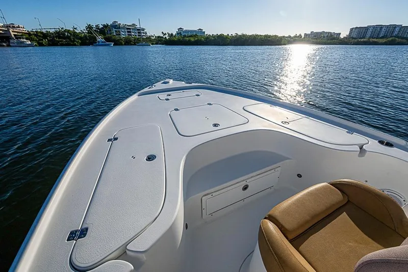 Slide: The Image of 2019 Sea Hunt BX 22 BR boat on calm water, sun reflecting on surface. - 35