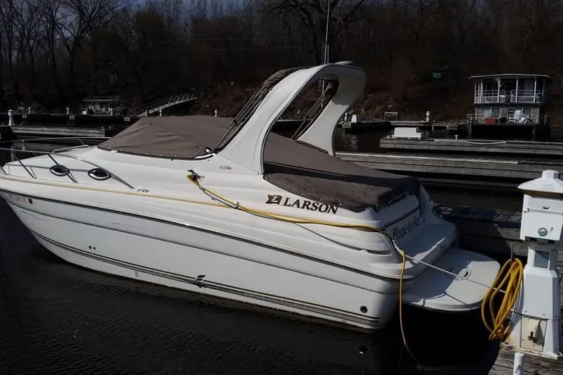 Slide: The Image of 2004 Larson Cabrio 260 boat docked at marina, covered and ready for use. - 2