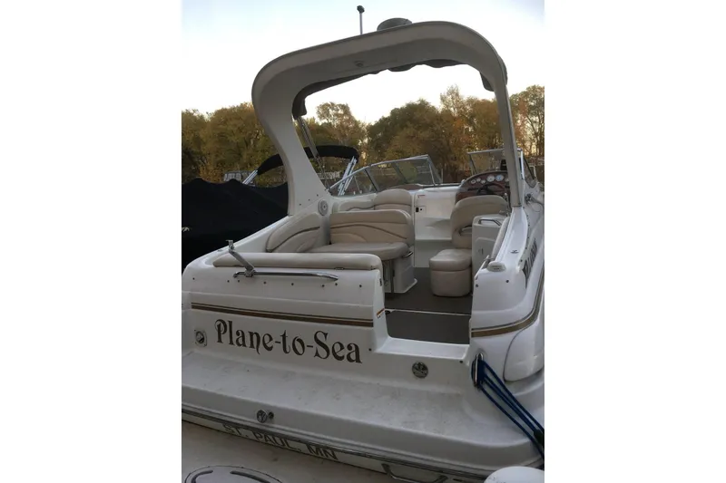 Slide: The Image of 2004 Larson Cabrio 260 boat with "Plane-to-Sea" name, docked outdoors. - 6
