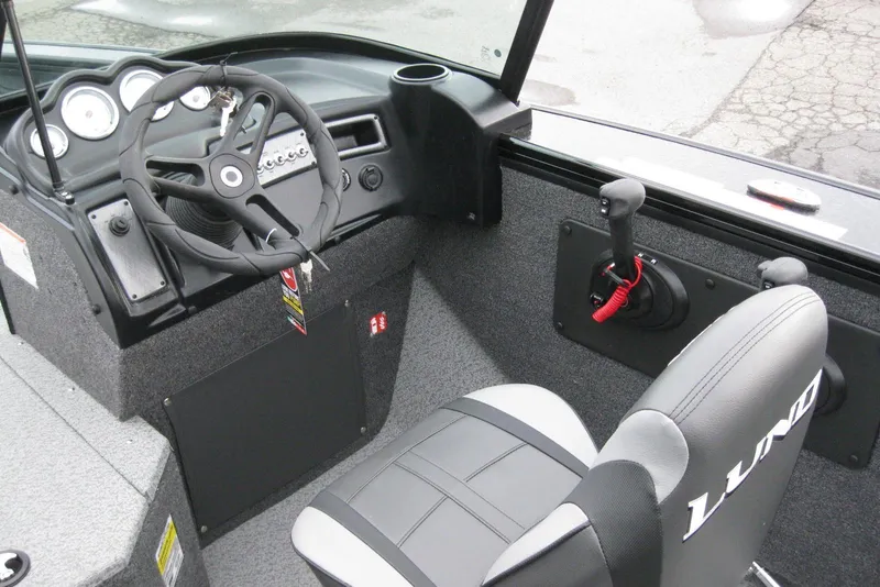 Slide: The Image of 2026 Lund 1875 Fisherman boat interior with steering wheel and control panel. - 16