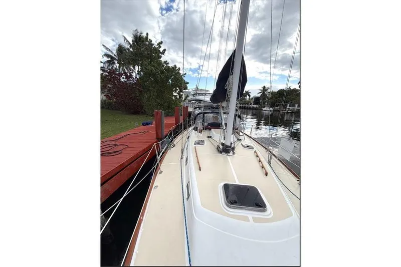 Slide: The Image of Sailboat docked by a red pier, Tartan 3700, 2001 model, under cloudy sky. - 14