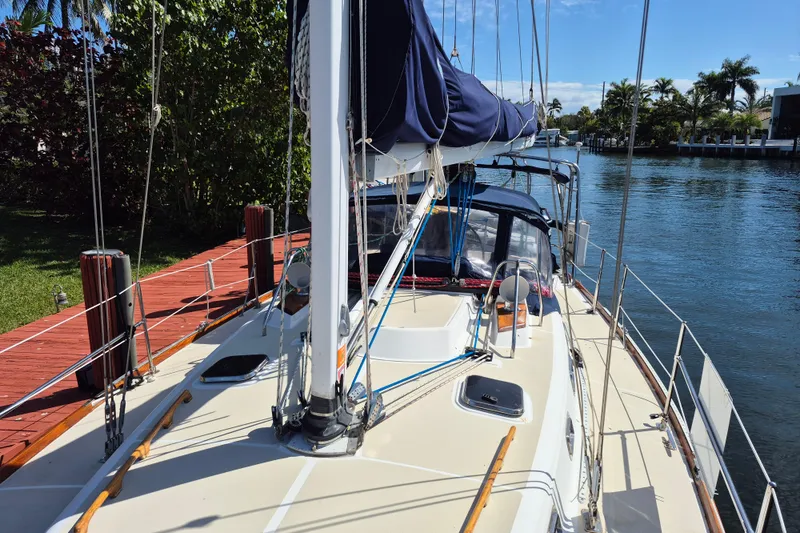 Slide: The Image of Sailboat docked by a canal, Tartan 3700 model, 2001, with lush greenery and clear skies. - 15
