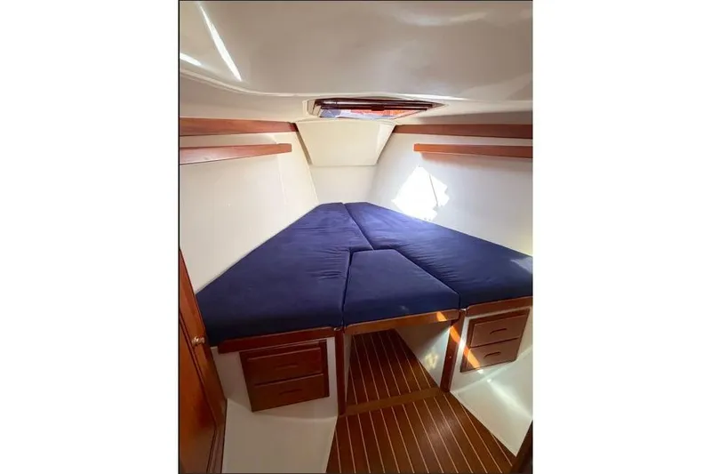 Slide: The Image of Interior cabin of 2001 Tartan 3700 sailboat with blue cushions and wooden accents. - 16