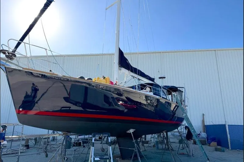 Slide: The Image of Tartan 3700 sailboat from 2001 in dry dock, with blue hull and red stripe. - 2
