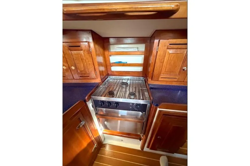 Slide: The Image of 2001 Tartan 3700 yacht kitchen with wooden cabinets and stainless steel stove. - 21