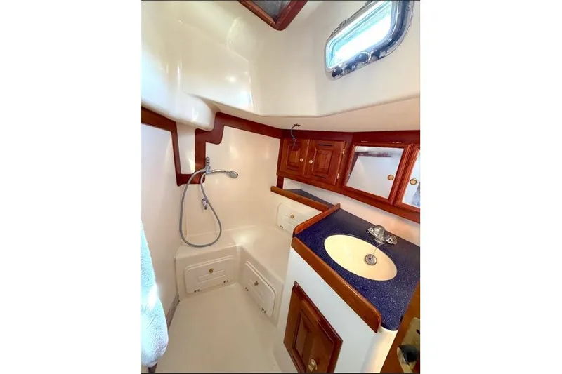 Slide: The Image of 2001 Tartan 3700 yacht bathroom with shower, sink, and wooden cabinetry. - 29