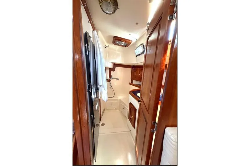 Slide: The Image of Interior of 2001 Tartan 3700 sailboat with wooden cabinetry and compact bathroom. - 30