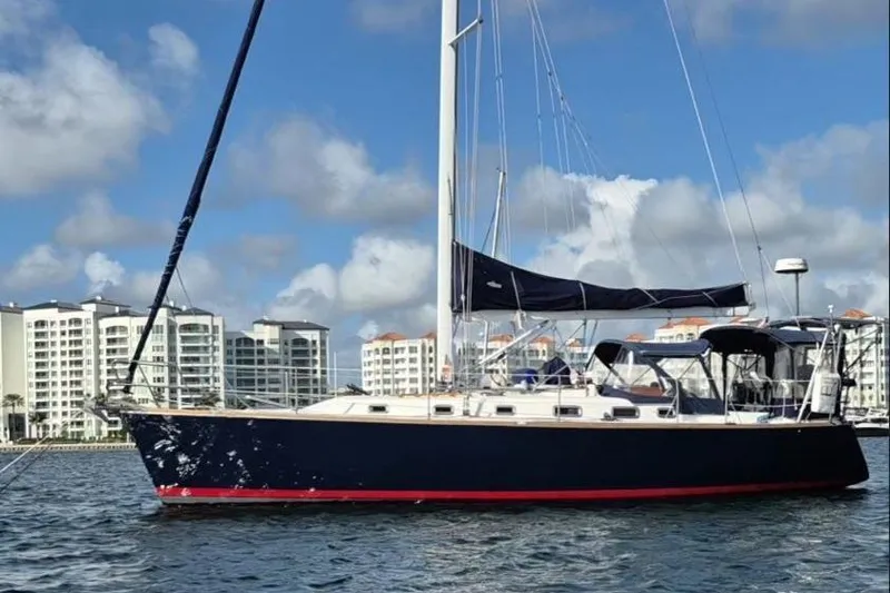 Slide: The Image of 2001 Tartan 3700 sailboat on water with cityscape background, under a partly cloudy sky. - 4