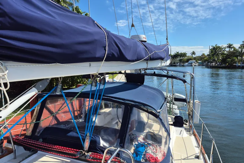 Slide: The Image of Sailboat Tartan 3700 (2001) docked by a scenic waterway with clear skies. - 8