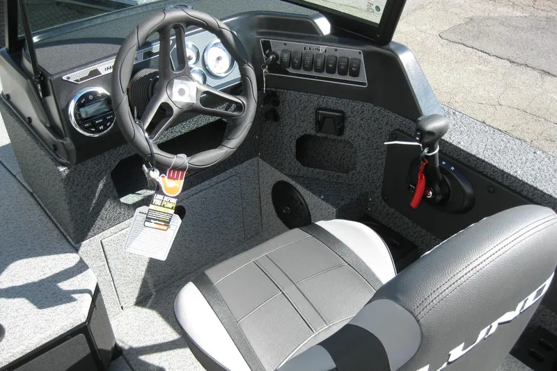 Slide: The Image of 2026 Lund 1775 Impact XS Sport boat interior with steering wheel and controls. - 11