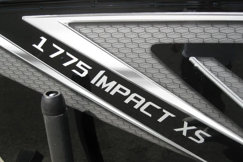 Slide: The Image of Close-up of 2026 Lund 1775 Impact XS Sport boat logo on textured surface. - 4