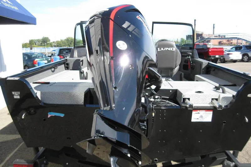 Slide: The Image of 2026 Lund 1775 Impact XS Sport boat with powerful outboard motor, parked outdoors. - 6
