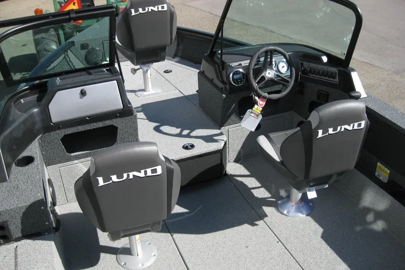 Slide: The Image of 2026 Lund 1775 Impact XS Sport boat interior with steering wheel and seating. - 7