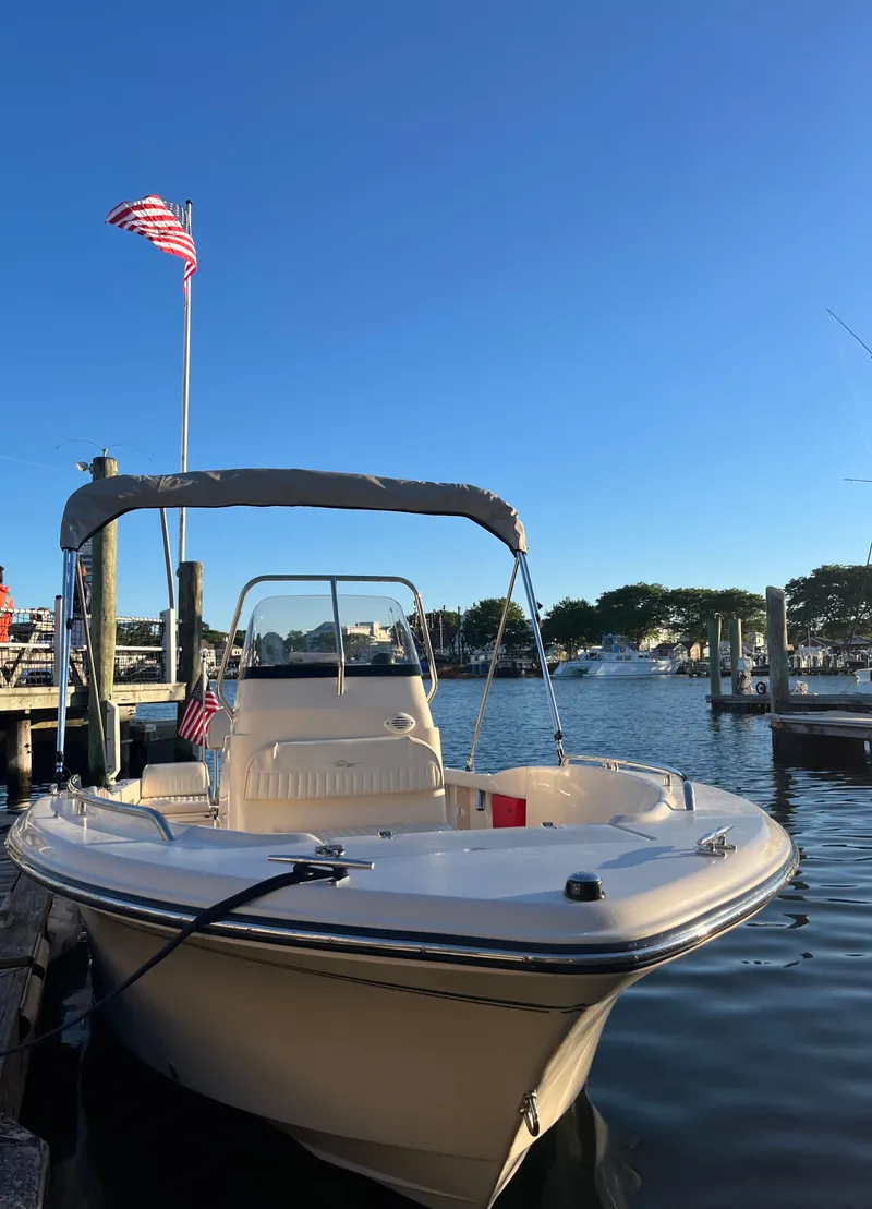 Slide: The Image of 2010 Grady-White Sportsman 180 boat docked, American flag, clear blue sky. - 5