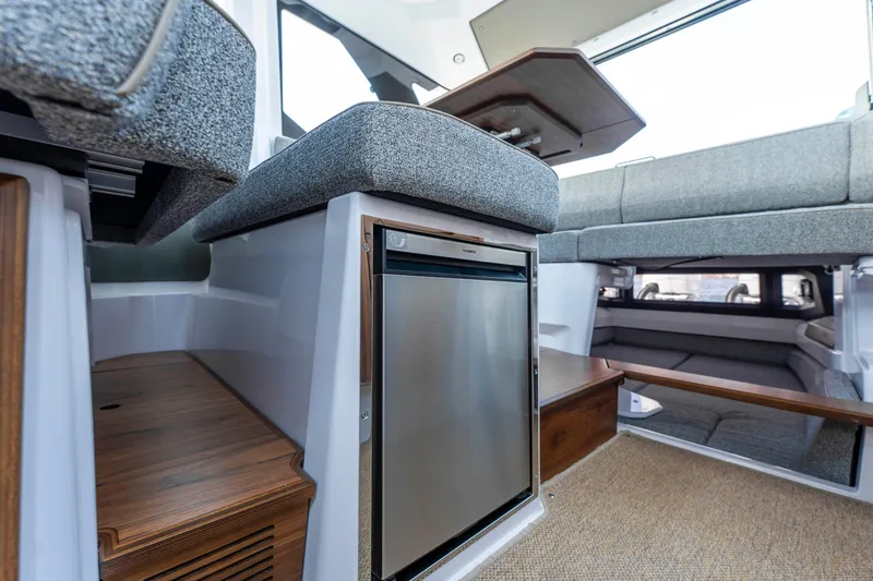 Slide: The Image of Interior of 2026 Axopar 38 Cross Cabin, featuring seating and compact refrigerator. - 26