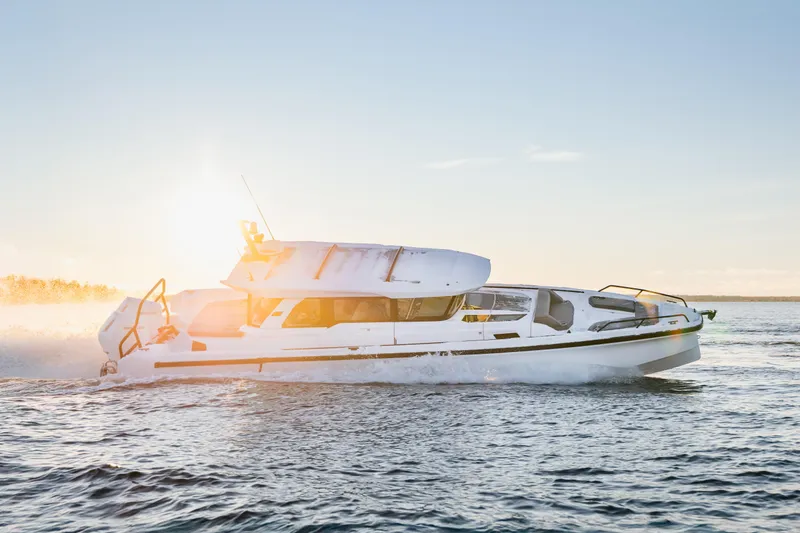 Slide: The Image of 2026 Axopar 38 Cross Cabin boat on a serene, misty lake. - 3