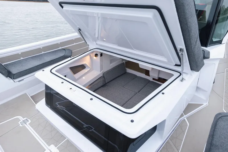 Slide: The Image of 2026 Axopar 38 Cross Cabin boat with cushioned seating on deck, near calm waters. - 8