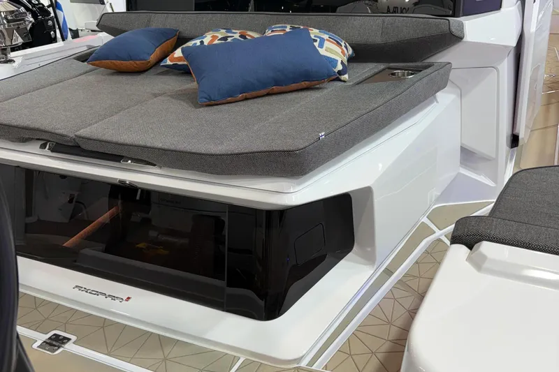 Slide: The Image of 2026 Axopar 38 Cross Cabin boat with open storage compartment and cushioned seating. - 9