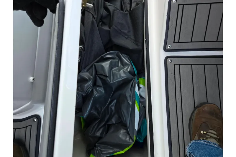 Slide: The Image of 2017 Yamaha Boats 242 Limited S E-Series storage compartment with gear and flooring. - 15