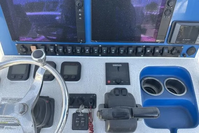 Slide: The Image of Control panel of a 2015 Sea Hunt Gamefish 25 boat with steering wheel and electronics. - 10