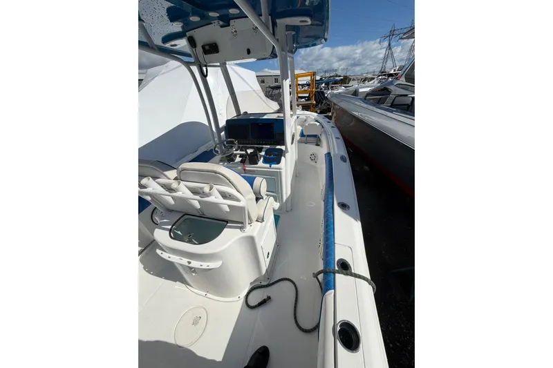 Slide: The Image of 2015 Sea Hunt Gamefish 25 boat interior with helm and seating, docked outdoors. - 11