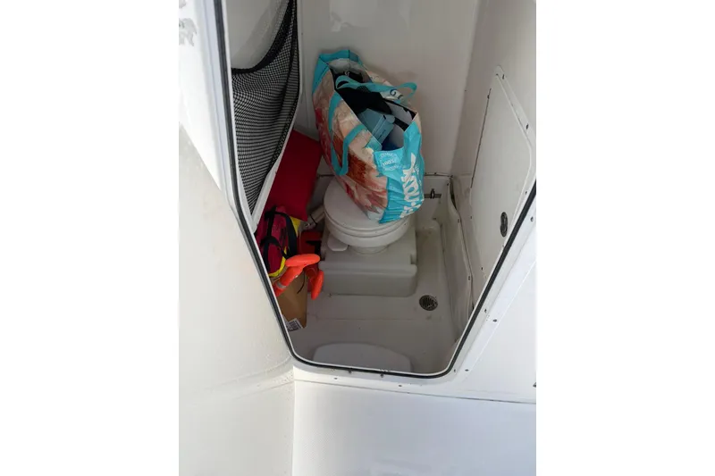 Slide: The Image of 2015 Sea Hunt Gamefish 25 boat interior with storage and toilet area. - 12