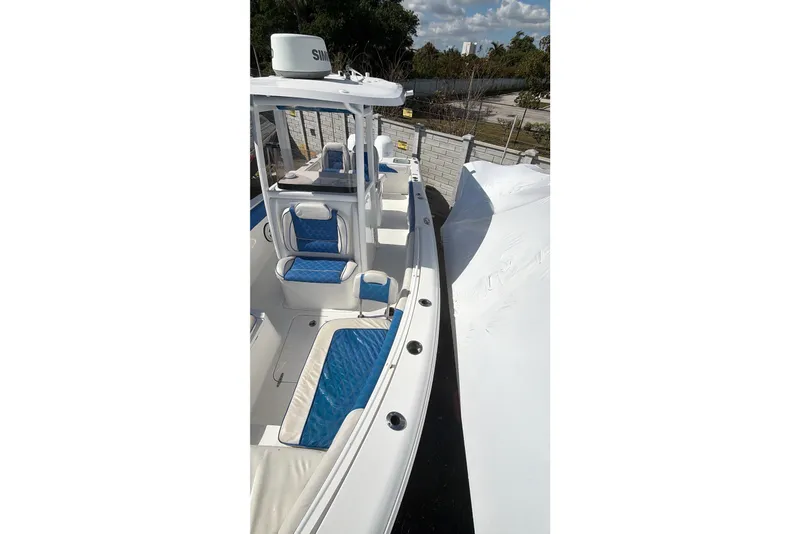 Slide: The Image of 2015 Sea Hunt Gamefish 25 boat with blue seating, docked outdoors. - 7